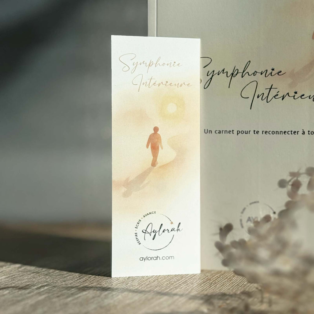 Marque-page Symphonie Intérieure avec carnet posé sur une table en bois